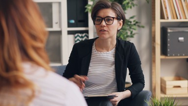 Young psychologist speaking with client.